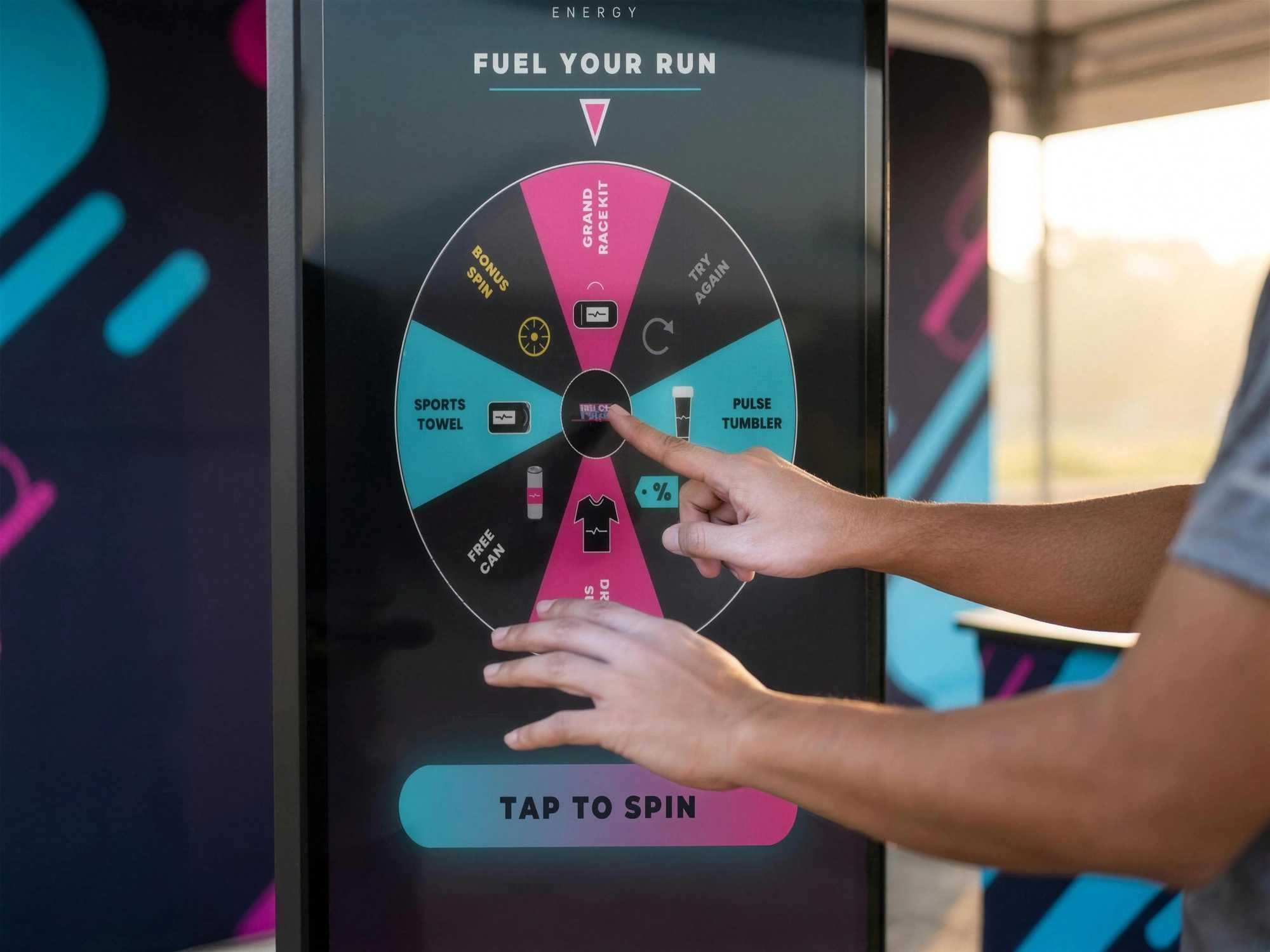 A guest's hands reaching for a branded Spin-to-Win game on the touchscreen of SlowMoManila's tall event kiosk.